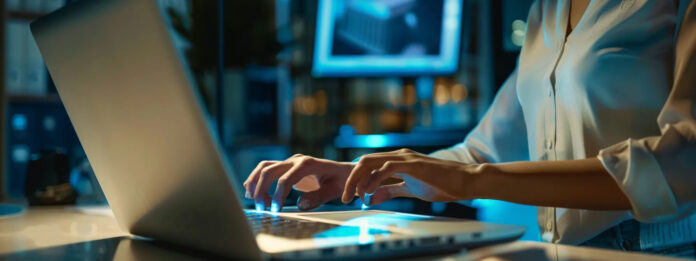 A Professional working on a laptop to manage documents securely using enterprise fax software.
